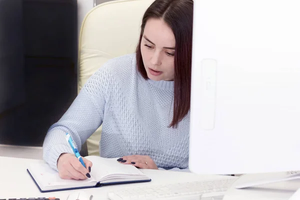 business woman writing plans or goals in notebook. working woman concept. beautiful woman at office work