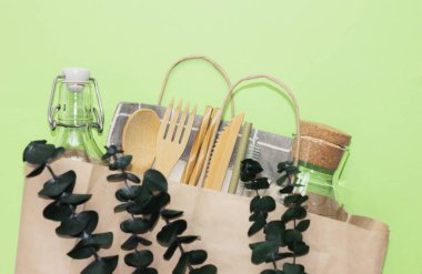 set of bamboo cutlery and glass bolltes in craft paper bag. eco friendly kitchen supply and zero waste concept.