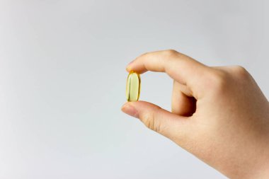 yellow medical capsule in human hand. Medicine treatment of diseases