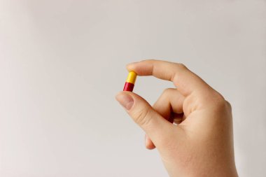 yellow and red medical capsule in human hand. Medicine treatment of diseases