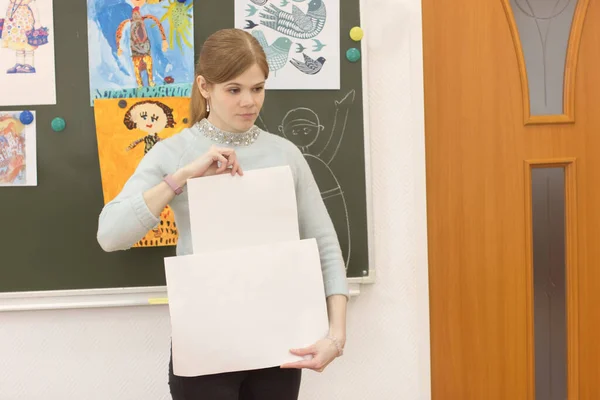 young beautiful art teacher explains children how to draw a picture.