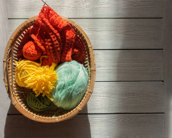 編み物糸針糸の皮 編み物用の春色 バスケットにオレンジと緑と黄色の糸 手で編む — ストック写真