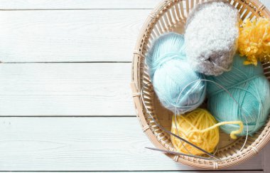 Örgü ipliği ve metal iğneler sepette. Üst Manzara. Mavi, nane ve sarı renkli iplik. metin için boşluk kopyala. Hobi olarak örgü örüyorum..