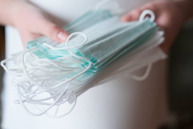 İnsan eli tıbbi yüz maskelerini tutuyor. Coronavirus veya COVID -19 önleme. Clobal salgını. Virüs yayıldı. çocuk ve yetişkinler için yüz maskeleri.