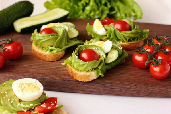 Sanduíches de pequeno-almoço saudáveis com abacate, tomate e pepino. foco seletivo — Fotografia de Stock