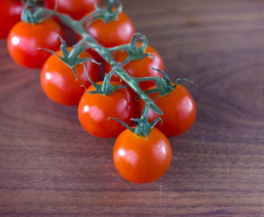 Ahşap bir yüzey üzerinde lezzetli kiraz domatesleri. 