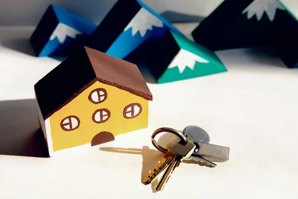 Brinquedo casa de madeira e montanhas e chaves de madeira . — Fotografia de Stock