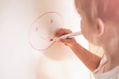 Beyaz tahtaya resim çizen tatlı sarışın kız.. 