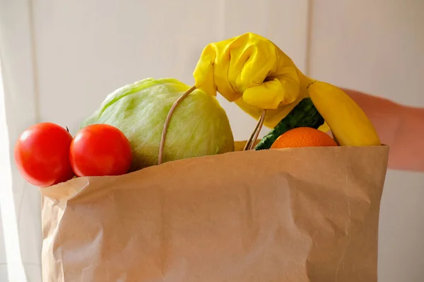 Delivery of a bag of vegetables and fruits and ingredients. Healthy food. Shopping bag with products. Food delivery coronavirus. Delivery by volunteers during the pandemic.