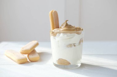 Buzlu köpüklü Dalgona kahvesi tiramisu, tiramisu tatlısının tepesinde yumuşacık kremalı kremalı kahve. Kahve köpüklü Kore kahveli espresso. Dekorasyon için savoyardi bisküvileri.