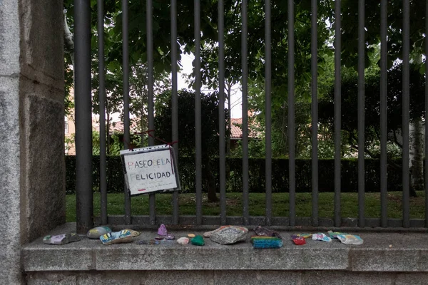 Mutluluk yolculuğu (Paseo de la felicidad). Caddenin ortasında karantina yardım girişimi. Madalyalı taşlar gezinti güvertesinin bir köşesine bırakılır. (Avila, İspanya; 05 / 19 / 2020) 