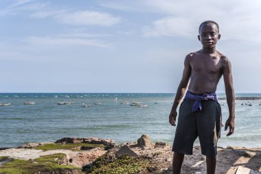 Arka planda Batı Afrika denizi olan Accra şehrinin dışında yüksek irtifada Gana 'dan gelen Afrikalı bir çocuk. 24 Eylül 2019