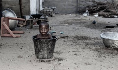 Afrikalı bir çocuk sıcak bir öğleden sonra bir kova suda serinliyor. Fotoğraf Ada Foah Gana Batı Afrika 'daki bir balıkçı köyünden..
