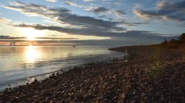 İsveç Baltık Denizi 'nin üzerinde Sunset' te taştan bir plajda tripodlu Nikon kamera. Fotoğraf: Skutskar İsveç, 6 Mayıs 2020