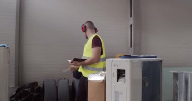 Bir adam, şantiyede çalışan bir işçi. İnşaat malzemelerinin envanteri ve teknik tamamlandı..