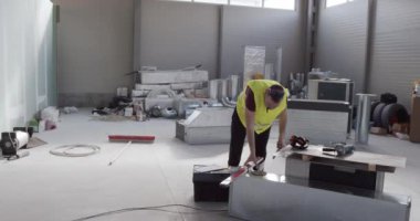 İnşaat mühendisi, işçi işe başlar ve aletlerini yanında taşır..