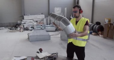 Bir inşaat işçisi, kanalizasyon borusunu kontrol ediyor. Araçlar ve ekipmanlar gözden geçirilir.