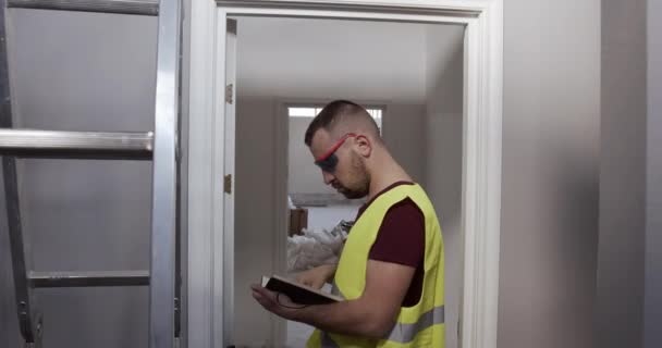 Homem Trabalhador Estaleiro Inspector Verifica Qualidade Das Obras Faz Anotações — Vídeo de Stock