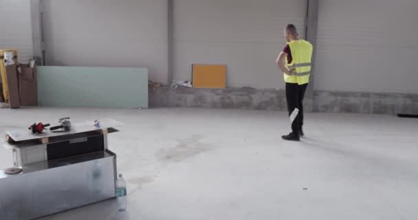 un ouvrier de la construction, parlant au téléphone et marchant irrité et agité .