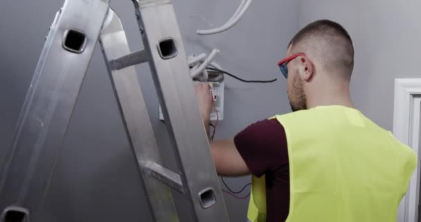 Een Mannelijke Elektrotechnicus Controleert Aansluitingen Spanning Kamer Van Een Huis — Stockvideo