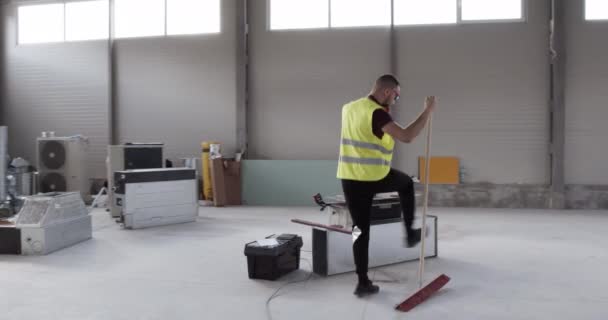 un employé, un ouvrier de la construction, se sent énergique et heureux au travail et danse tout en travaillant .