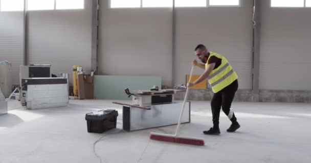 un employé, un ouvrier de la construction, se sent énergique et heureux au travail et danse tout en travaillant .