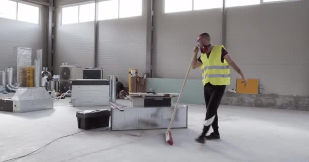 un employé, un ouvrier de la construction, se sent énergique et heureux au travail et danse tout en travaillant .