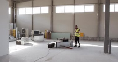 İnşaat mühendisi telefonda konuşuyor ve çalışma planını ve inşaat alanındaki nesneyi kontrol ediyor..