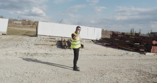 Bir Adam Bir Inşaat Işçisi Şantiyede Yürüyen Gerçekleştirilen Işlerin Planını — Stok video