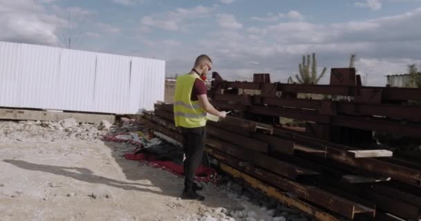 Trabalhador Engenheiro Caminha Pelo Canteiro Obras Com Plano Mãos Verifica — Vídeo de Stock