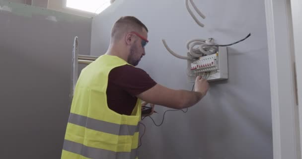 Engenheiro Elétrico Masculino Verifica Conexões Tensão Sala Uma Casa Construção — Vídeo de Stock