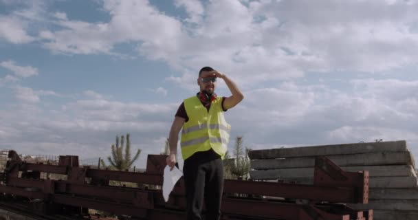 Trabalhador Engenheiro Caminha Pelo Canteiro Obras Com Plano Mãos Verifica — Vídeo de Stock