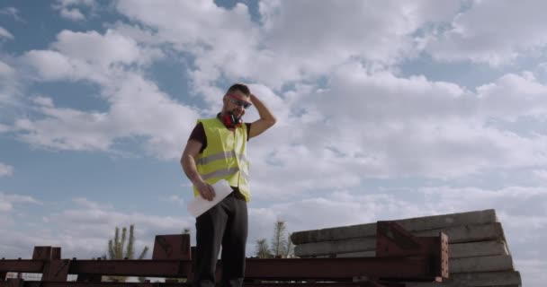 Working Man Engineer Walks Construction Site Plan Hand Checks Progress — Stock Video
