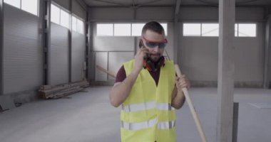 Bir adam, bir inşaat işçisi, şantiyede yürüyen ve gerçekleştirilen işlerin planını kontrol eden bir mühendis..
