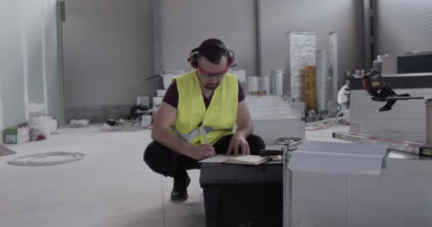 l'ingénieur note dans le carnet et vérifie la qualité des travaux effectués par ses subordonnés .