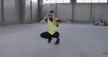 Kızgın bir inşaat işçisi, telefonda sinirli ve kötü konuşuyor, ellerini kaldırıyor ve titriyor..
