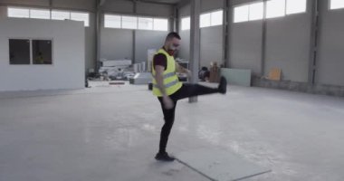 Kızgın bir adam, tedirgin konuşuyor ve ellerini kaldırıp titriyor..