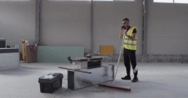 Bir adam, bir inşaat işçisi, şantiyede yürüyen ve gerçekleştirilen işlerin planını kontrol eden bir mühendis..