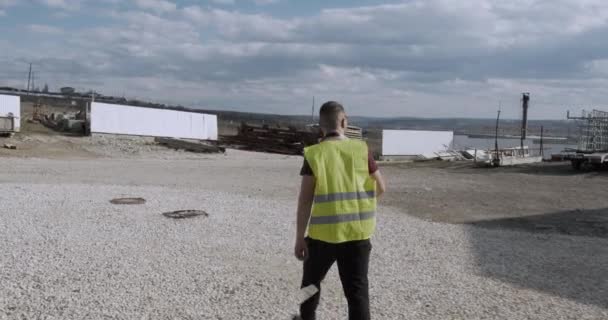 Trabajador Ingeniero Camina Por Sitio Construcción Con Plan Mano Comprueba — Vídeos de Stock