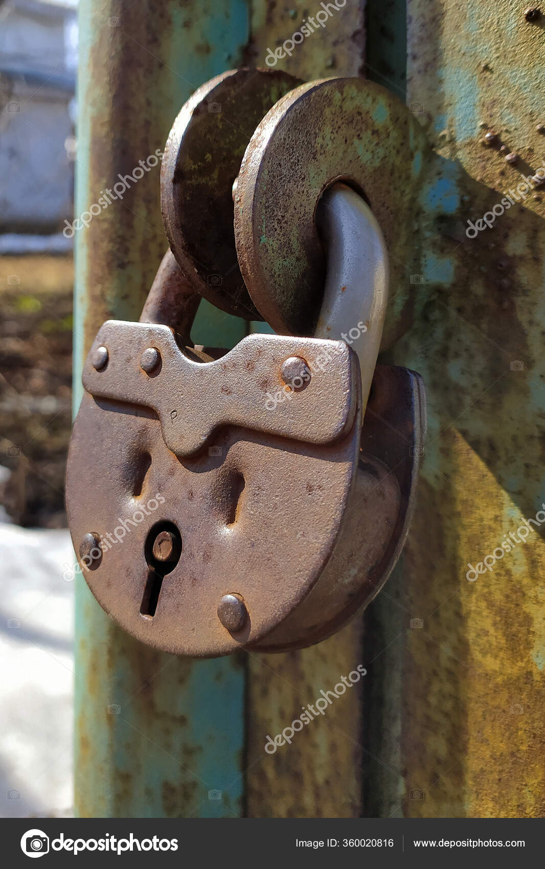 An old, rusty padlock with a chain hanging from the gate — Stock