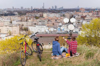 Birlikte eğlenen, çay içen ve şehir manzarası seyreden bir çift.