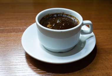 Tahta arka planda bir fincan kahve.