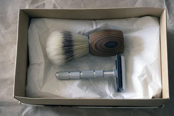 Shaving accessories: shaving brush and razor.