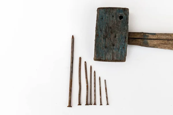 Старый деревянный молоток и ржавые ногти на белом фоне — стоковое фото