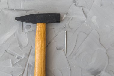 Gri beton arka planda inşaat çekici ve çiviler