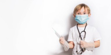 Steteskopla izole edilmiş bayrağı olan tıbbi maskeli şirin küçük kız.