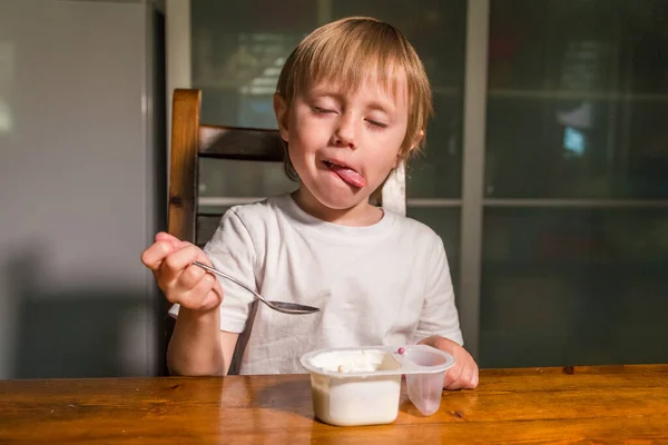 Adorabile bambina che mangia fiocchi di latte da cucchiaio, spuntino al latte sano . — Foto Stock
