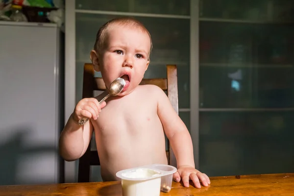 Bambino adorabile che mangia fiocchi di latte da cucchiaio, spuntino di latte sano . — Foto Stock