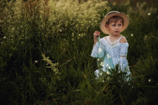 Petite fille mignonne dans une robe blanche et chapeau dans le domaine à l'heure du coucher du soleil — Photo