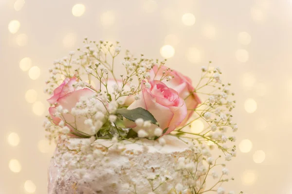 Primer plano de hermoso pastel de nivel de árbol blanco con flores frescas con bastante luz y linternas que brillan en el fondo. Enfoque selectivo. Copiar espacio . — Foto de Stock